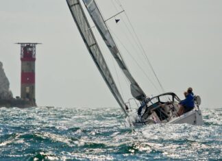 Planning a Sailing Weekend in the Solent Sailing yacht passing the Needles lighthouse off the Isle of Wight.