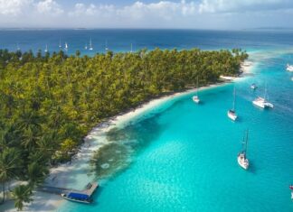 Yachts anchored beside a tropical island.