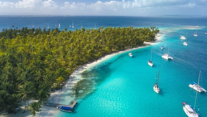 Yachts anchored beside a tropical island.