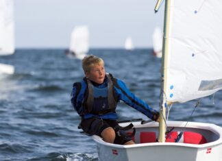 What to Wear Sailing in the UK: Dinghy and Yacht Kit Explained Young dinghy sailor wearing a buoyancy aid.